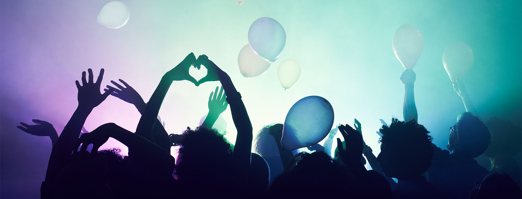 young people having fun at a party with a balloons floating in the air