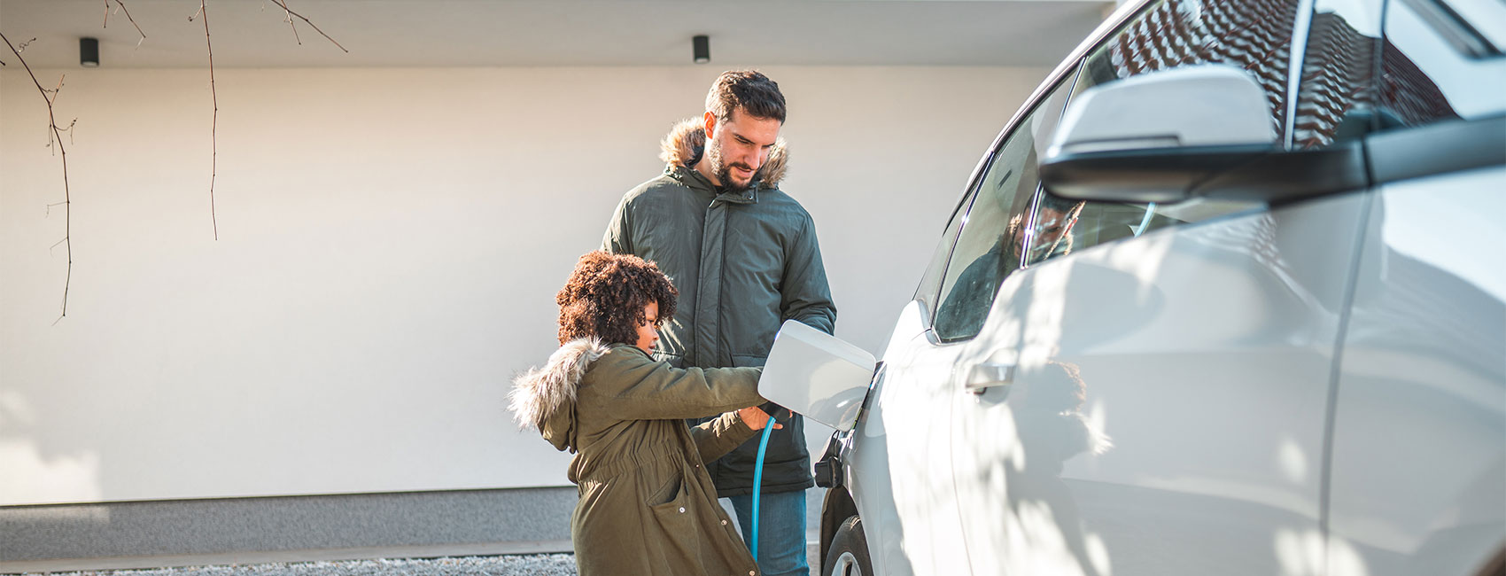 Father is teaching his daughter to charge EV car