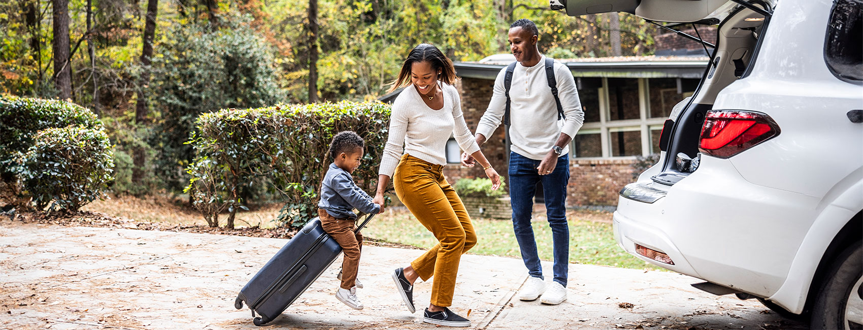 Family of three is  loading car for their family vacation